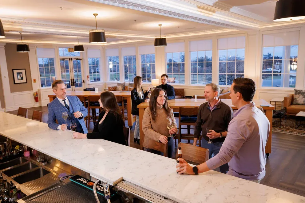 a group of people standing around a bar