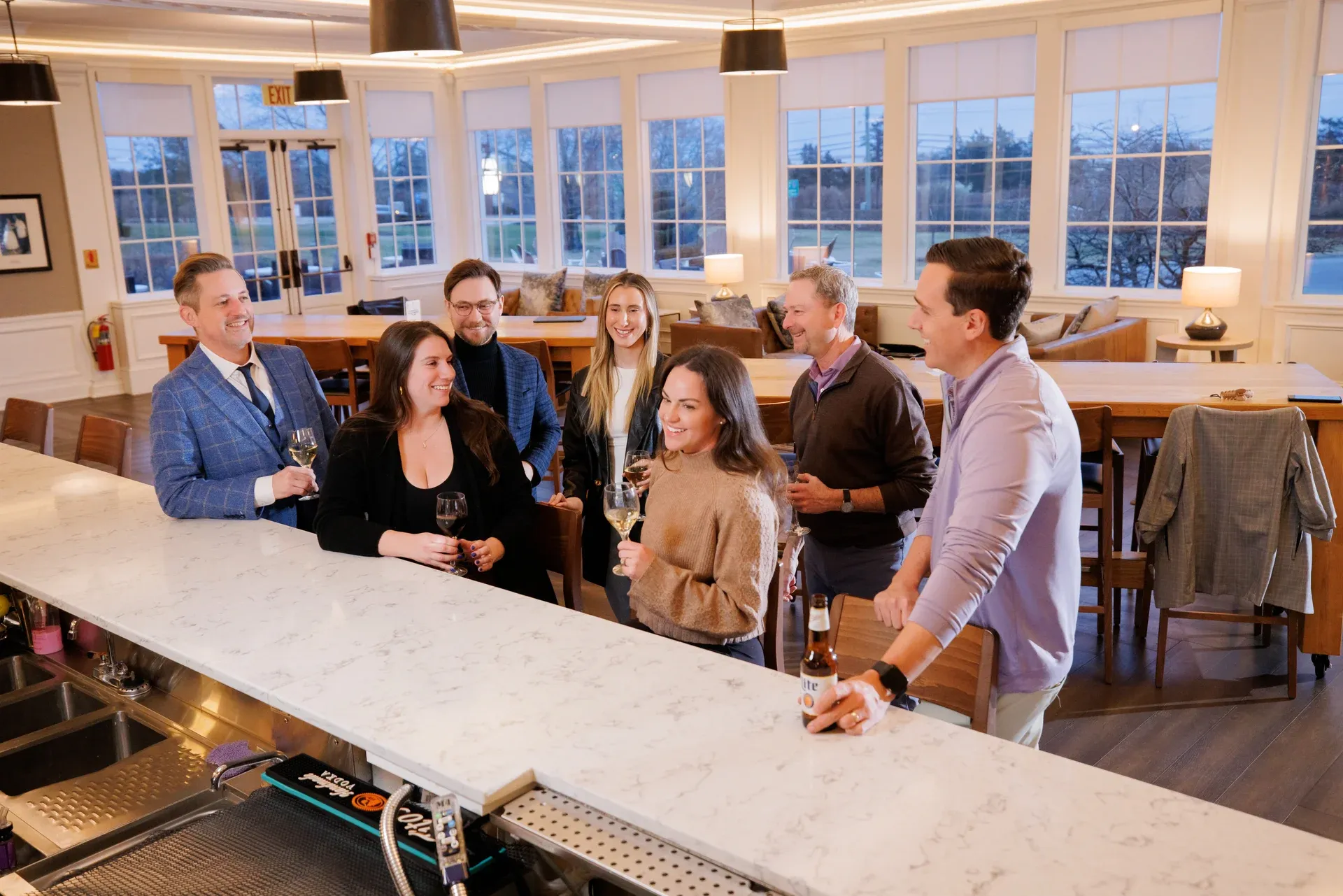 a group of people standing around a bar