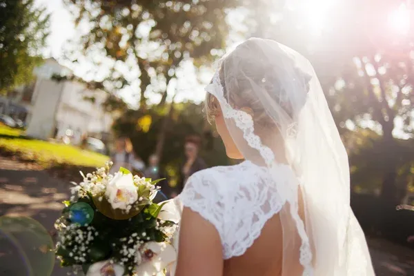 a woman in a white dress with a bouquet of flowers